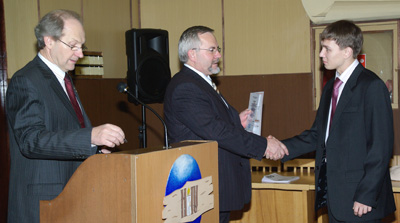Фото (слева направо): президент НовГУ А.Л. Гавриков и ректор НовГУ В.Р. Вебер поздравляют студента.